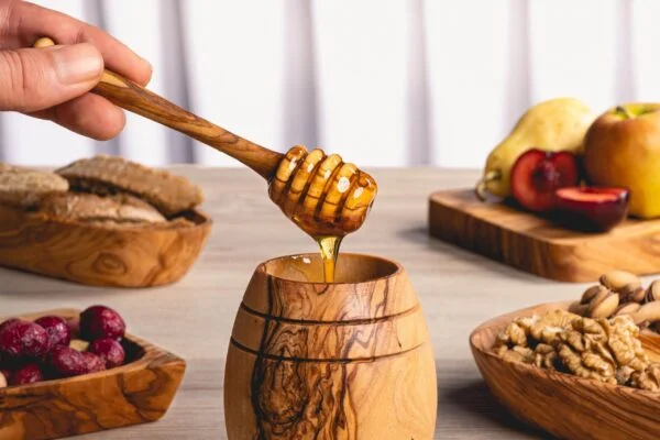وعاء عسل مع ملعقة من خشب الزيتون